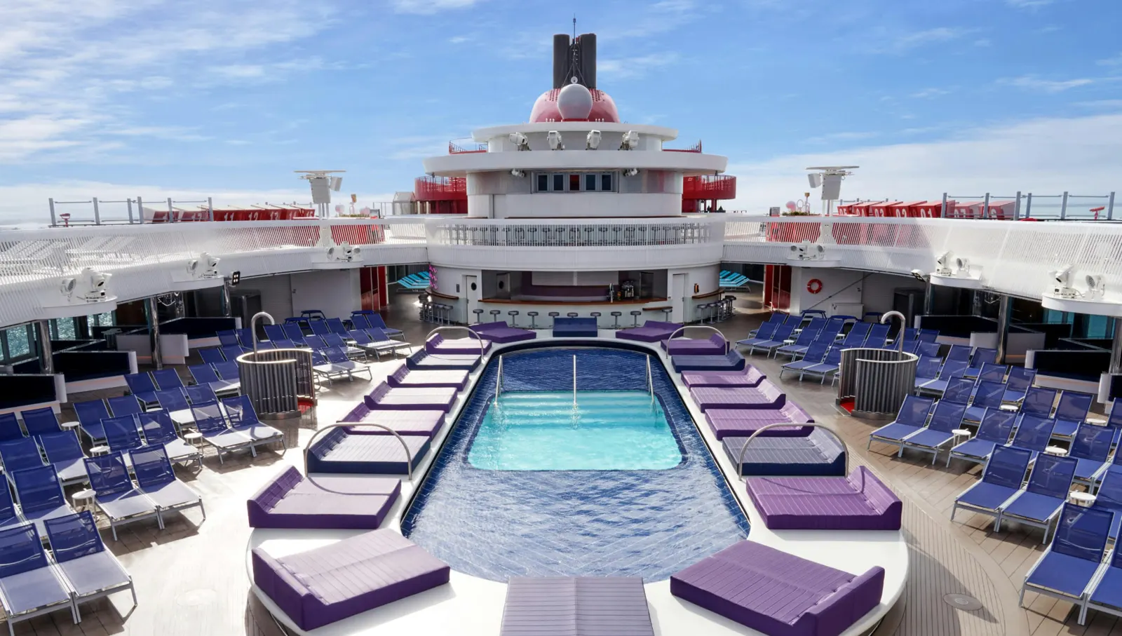 Pool deck with sun loungers on a Virgin Voyages ship