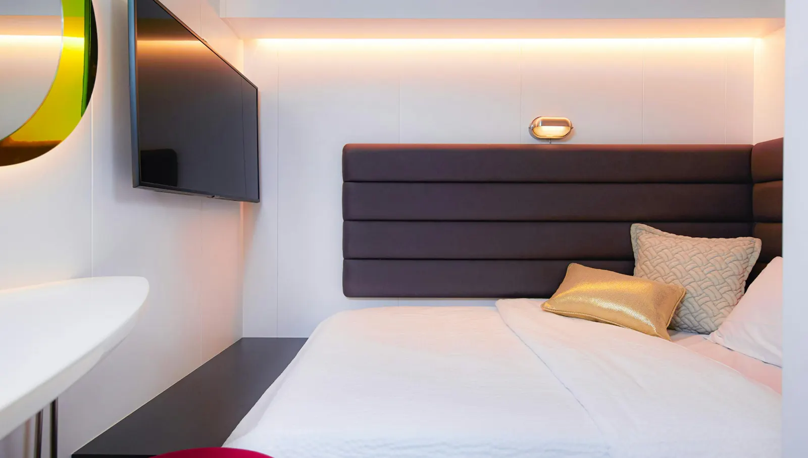 Bed with cushions inside a Virgin Voyages cabin