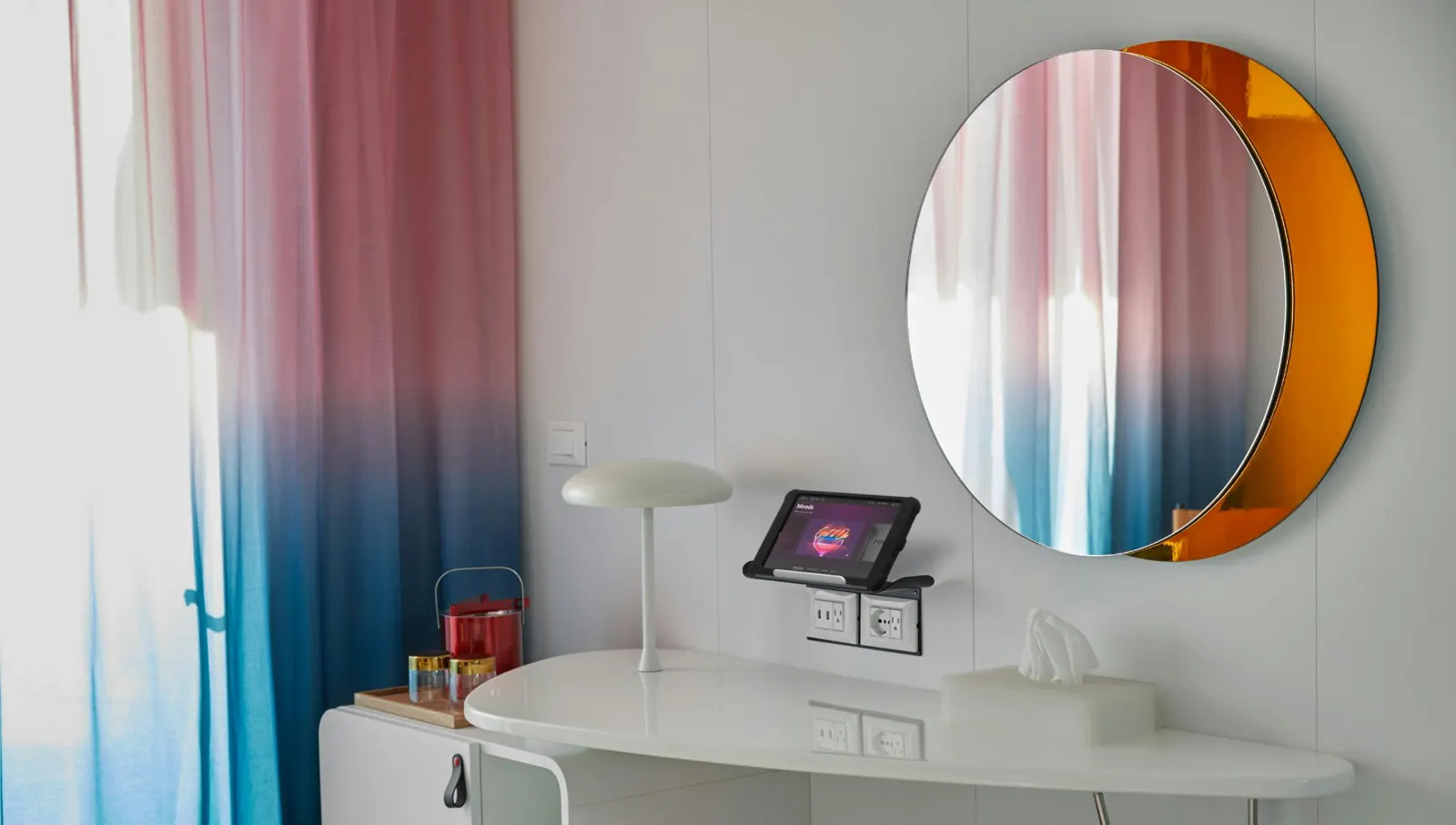 Cabin vanity with round mirror and tablet on a Virgin Voyages ship